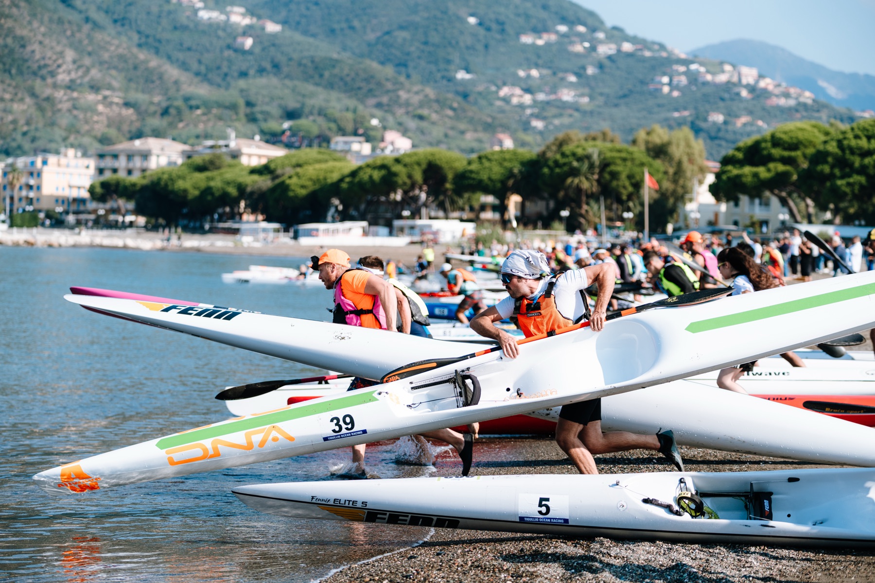 Atleti portano i surfski in acqua dalla spiaggia di Sestri Levante